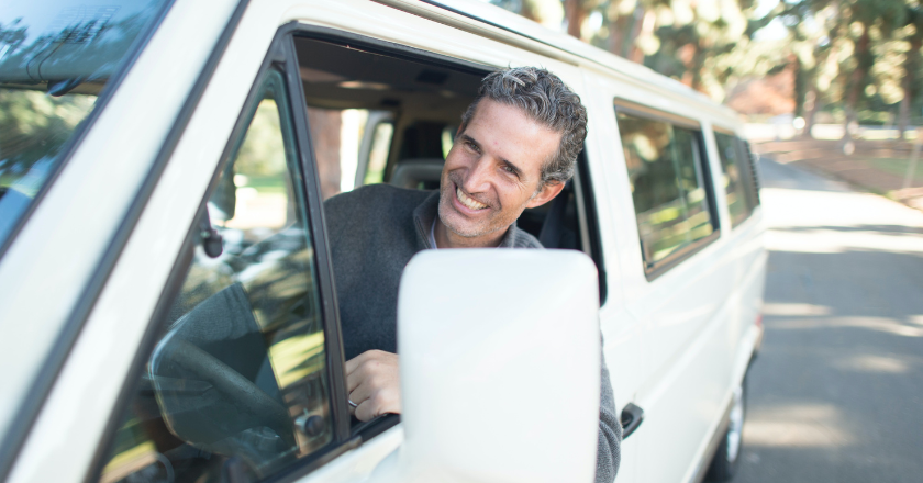 A man smiling in a van