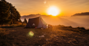 A Decathlon tent on the summit of a mountain at sunset